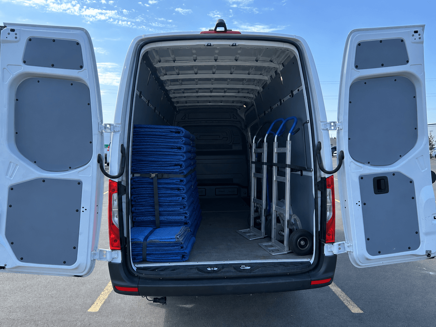 Reliable Movers Sprinter van loaded with moving blankets, rear doors open